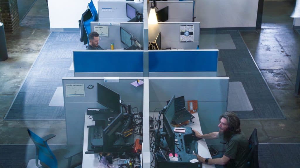 Employees working in cubicles to provide support for cloud services